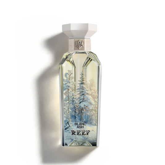 Perfume bottle labeled 'Reef' with a winter scene design on a white background