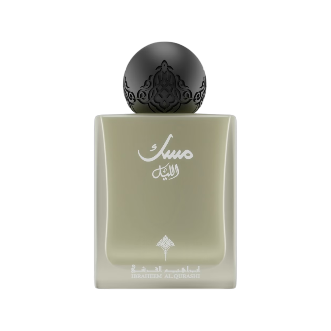 A rectangular glass perfume bottle with a pale sage green body, featuring white Arabic calligraphy on the front and a glossy black spherical cap with ornate cutout detailing, set against a plain white background.
