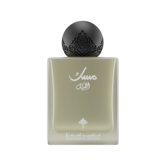 A rectangular glass perfume bottle with a pale sage green body, featuring white Arabic calligraphy on the front and a glossy black spherical cap with ornate cutout detailing, set against a plain white background.