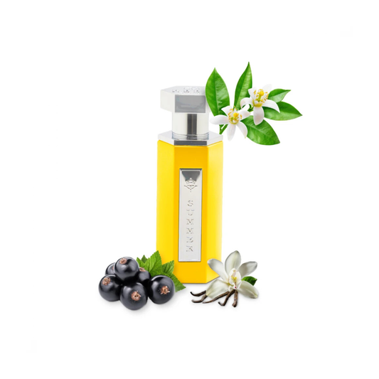 A yellow hexagonal perfume bottle with a silver cap, decorated with white flowers and green leaves, with black berries at its base, on a white background.