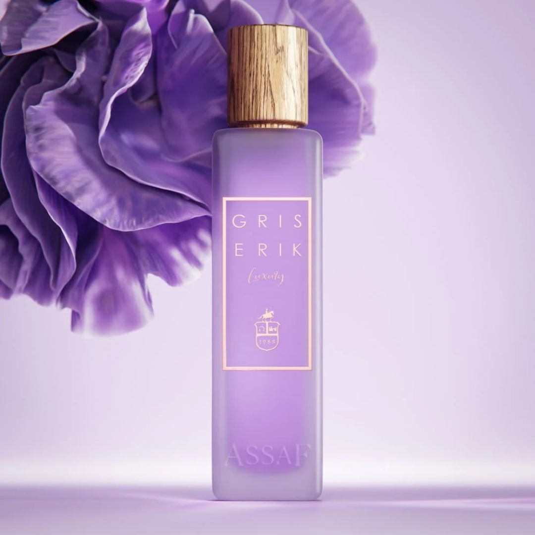 Perfume bottle with gold cap and 'Gris Erik' branding against a purple floral background